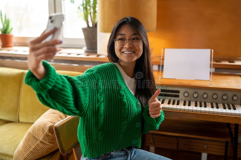 Adorável garota asiática fazendo selfie e sorrindo fotografia de stock