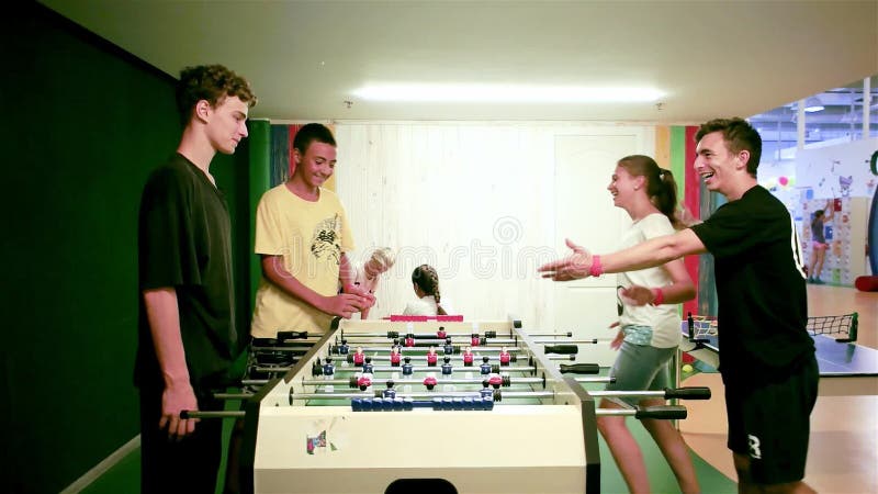 Ados jouant le football de table, groupe d'enfants traînant ainsi que le football de table, travail d'équipe