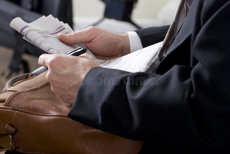 A man holding the classified section of the newspaper as if searching for possible employment. A man holding the classified section of the newspaper as if searching for possible employment.