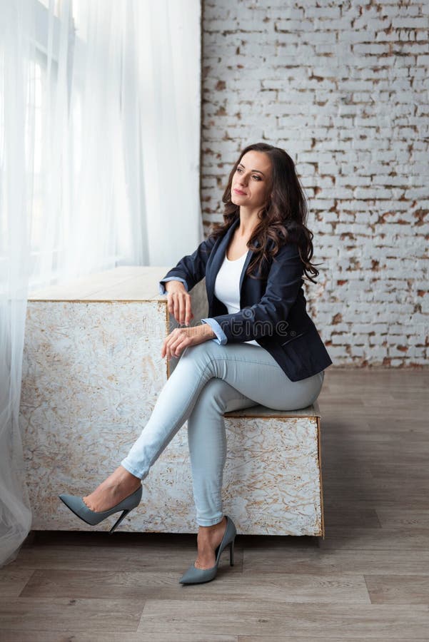 Adult attractive businesswoman sitting in the office looking thoughtfully out the window stock images Adult attractive businesswoman sitting in the office looking thoughtfully out the window stock images