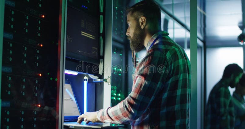 Bearded IT specialist setting servers in data center stock photos