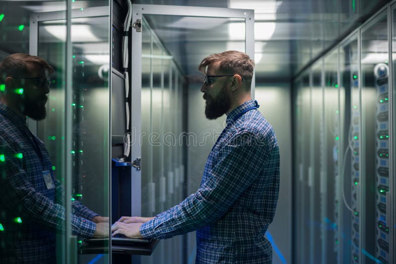 Bearded IT specialist setting servers in data center royalty free stock photography