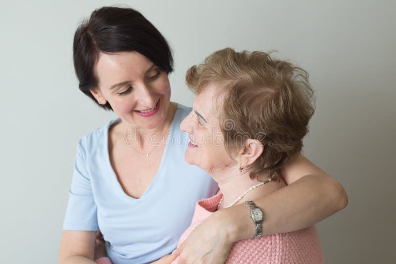 Adult daughter hugging elderly mother concept connection. 