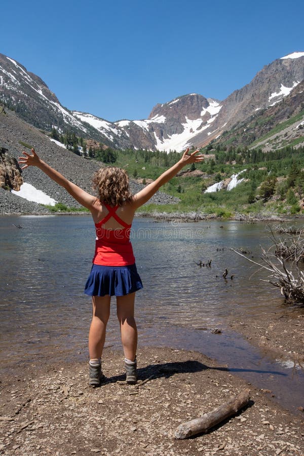 Adult female hiker with back facing the camera, and arms raised in Lundy Canyon near Mammoth Lakes in the Eastern Sierra Nevada stock photos Adult female hiker with back facing the camera, and arms raised in Lundy Canyon near Mammoth Lakes in the Eastern Sierra Nevada stock photos