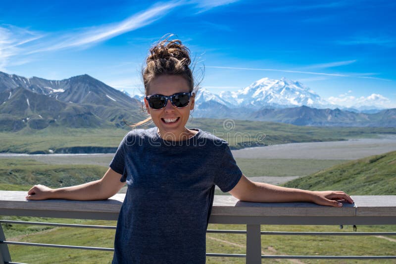 Adult female stands in front of Denali mountains in the Alaska Range stock images Adult female stands in front of Denali mountains in the Alaska Range stock images