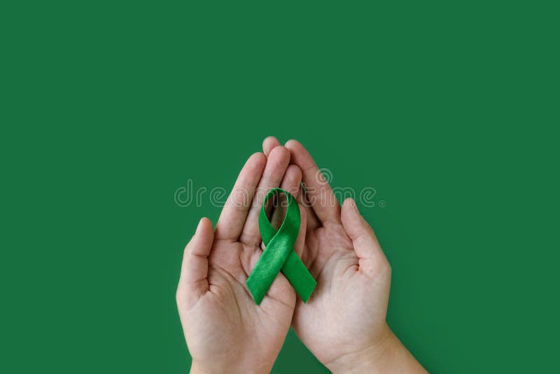 Un adulto manos verde cinta sobre el verde.