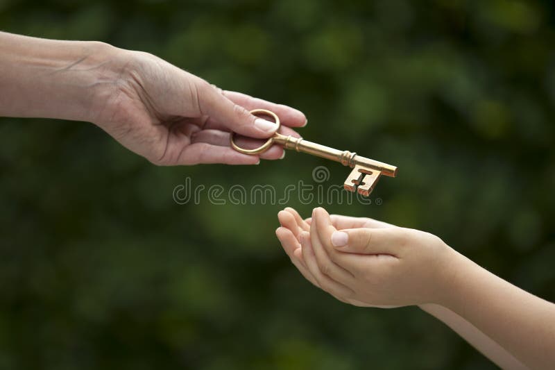 Adult hands key to child stock image