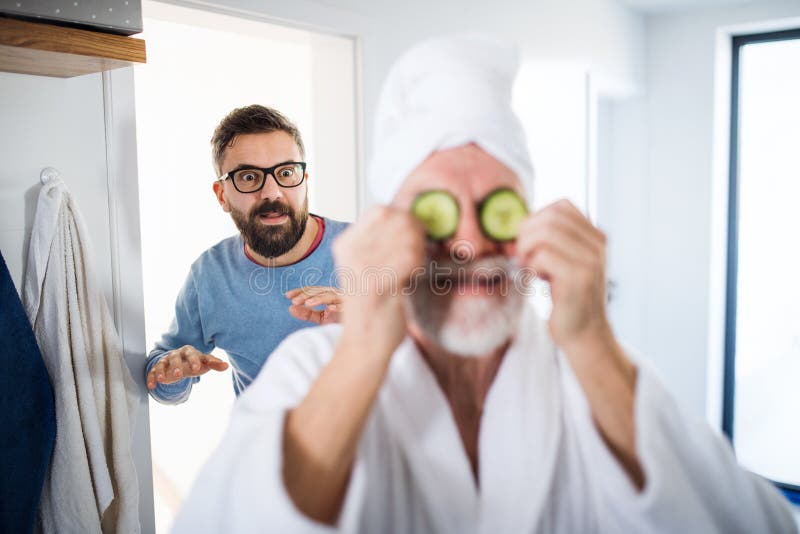 An adult hipster son and senior father in bathroom indoors at home, having fun. royalty free stock photos An adult hipster son and senior father in bathroom indoors at home, having fun. royalty free stock photos