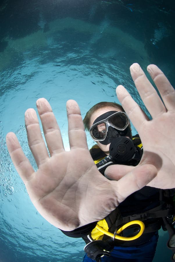 Adult male scuba diver showing his hands.