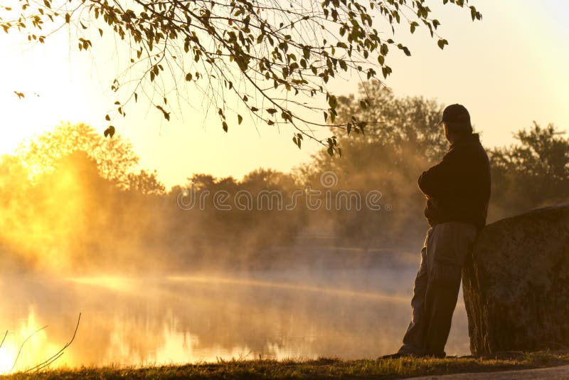 Adult Male Stands Alone At Sunrise Staring Towards royalty free stock image Adult Male Stands Alone At Sunrise Staring Towards royalty free stock image