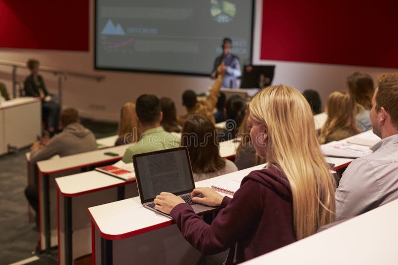 Adult student using laptop computer at a university lecture. College, incidental.