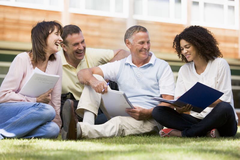 Adult students sitting on a campus lawn stock images Adult students sitting on a campus lawn stock images