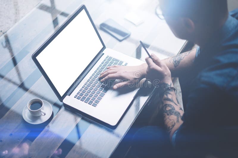 Adult tattooed businessman working on mobile computer at sunny office. Businessman typing on notebook keyboard. White stock image Adult tattooed businessman working on mobile computer at sunny office. Businessman typing on notebook keyboard. White stock image