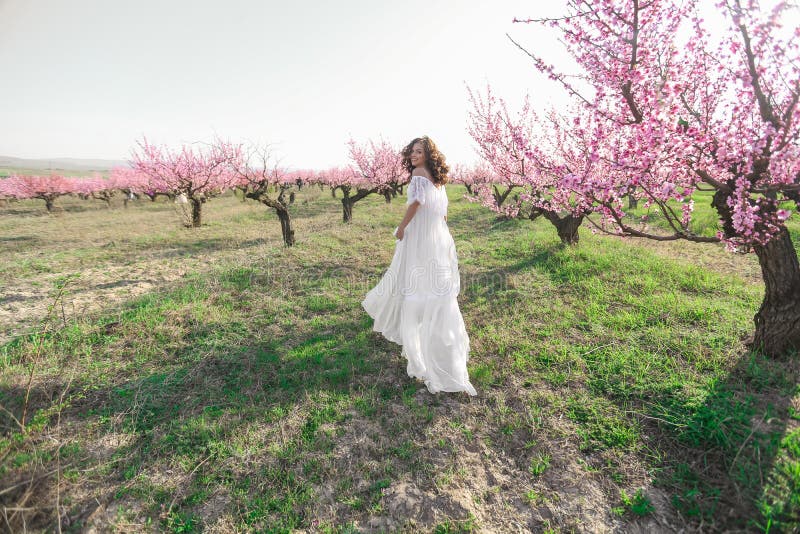 A Woman in a Beautiful Blue Dress Near a Round Haystack in a Field of ...