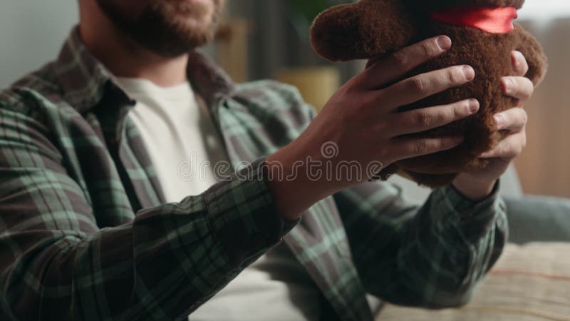 Adulte heureux homme caucasien à l'intérieur tenant peluche jouet confortable en train de préparer cadeau cadeau cadeau pour enfan banque de vidéos