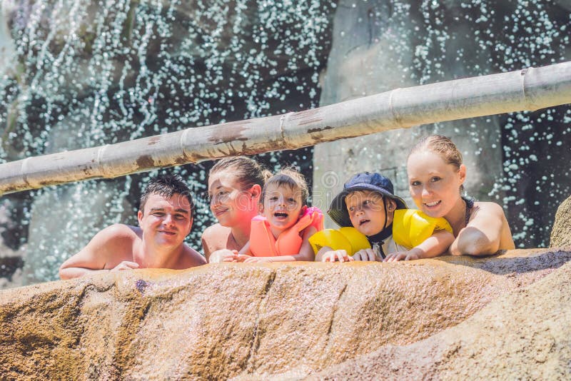 Adultes et enfants heureux dans un parc aquatique images libres de droits Adultes et enfants heureux dans un parc aquatique images libres de droits
