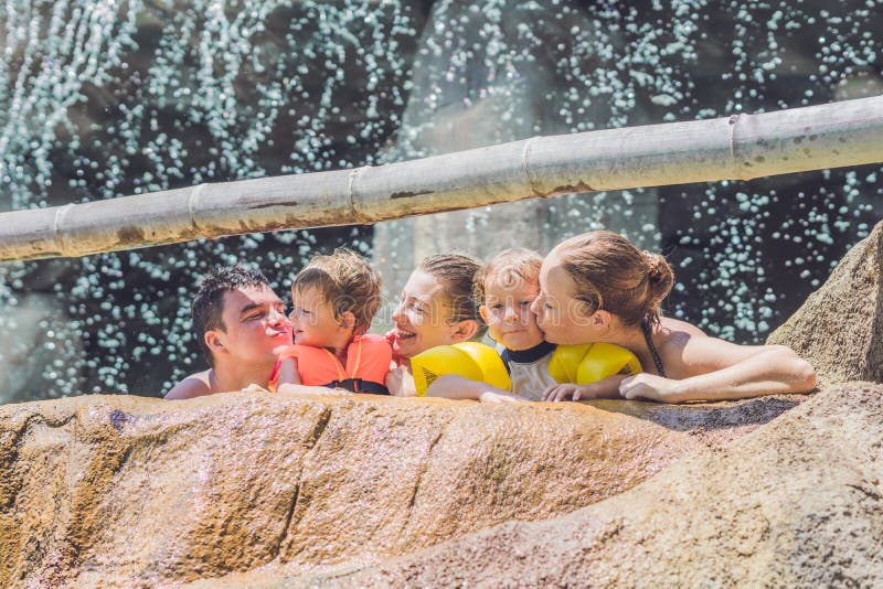 Adultes et enfants heureux dans un parc aquatique image libre de droits Adultes et enfants heureux dans un parc aquatique image libre de droits