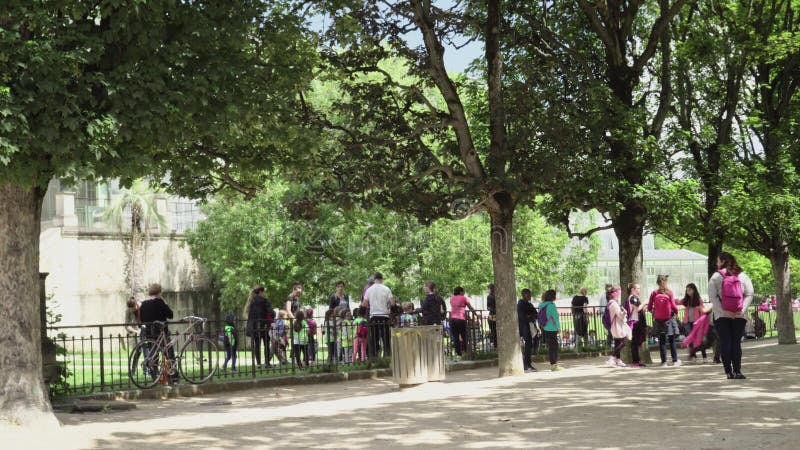 Adulti e bambini nel giardino botanico vicino alla serra a Parigi