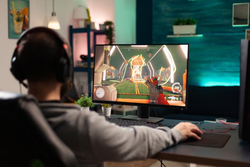 Adultos jugando videojuegos en el monitor con ratón foto de archivo