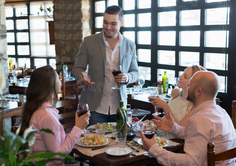 Adults Having Dinner in Restaurant Stock Image - Image of clothes