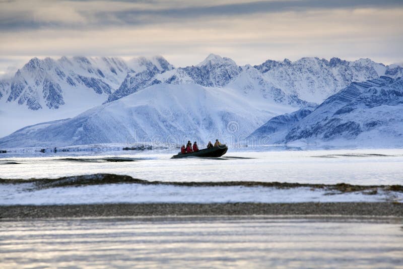 Adventure tourists - Svalbard Islands - Arctic. Adventure tourists on a zodiac in Raudfjord on the Svalbard Islands (Spitsbergen) in the High Arctic royalty free stock photography Adventure tourists - Svalbard Islands - Arctic. Adventure tourists on a zodiac in Raudfjord on the Svalbard Islands (Spitsbergen) in the High Arctic royalty free stock photography