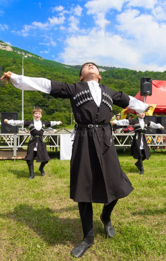 Adyghe chłopiec w czerkiesów krajowych kostiumach tanczy etniczny festiwal w górach Adygea fotografia stock