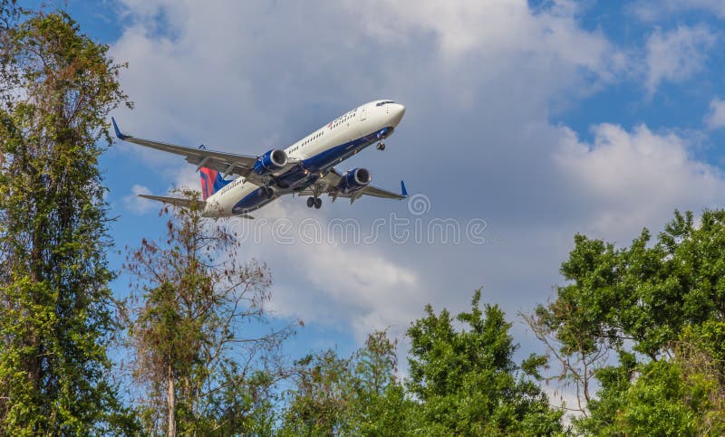 Aereo di linea che atterra gli alberi vicini bassi immagini stock libere da diritti Aereo di linea che atterra gli alberi vicini bassi immagini stock libere da diritti