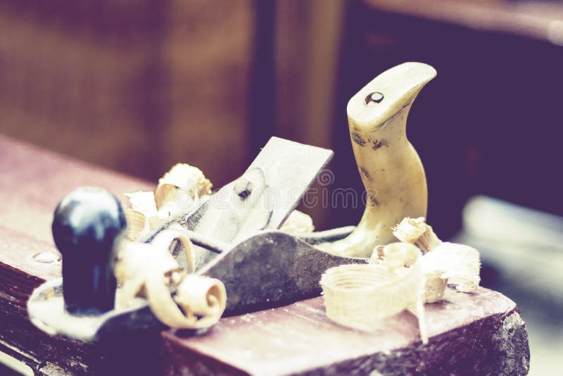 Aereo e chip di legno del †di falegnameria vecchi «in un'officina del carpentiere, retro concetto immagini stock libere da diritti Aereo e chip di legno del †di falegnameria vecchi «in un'officina del carpentiere, retro concetto immagini stock libere da diritti
