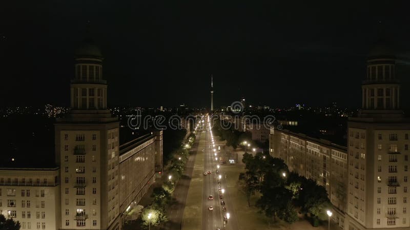 Aererivy över tom karlmarxallee-gata nattetid mot alexander platz tv-torn i berlin-gromånga under kovid 19