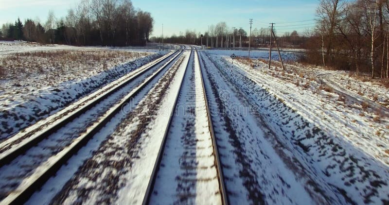 AERIAL. Camera flight from train tracks to the high winter sunset sky. 4k