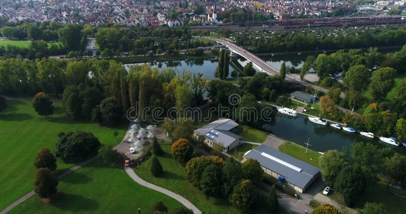 Aerial copter flight over beautiful greeny Heilbronn and famous Erwin-Fuchs bridge across Neckar River in Germany. 4k