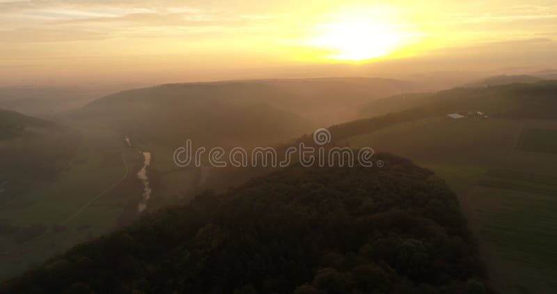 Aerial copter flight over the charming misty fields, mountains and forests during the sunset in Heilbronn, Germany. 4k