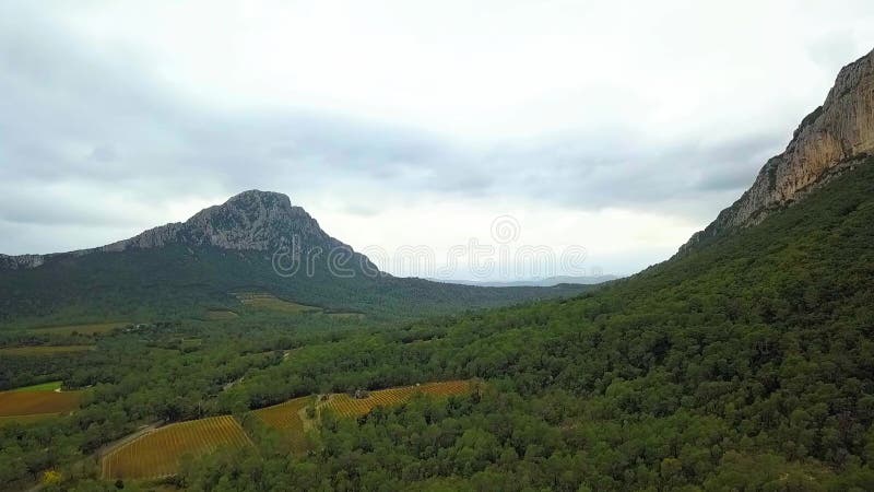 Aerial Drone Footage View: Flight between cloudy mountains Pic Saint Loup