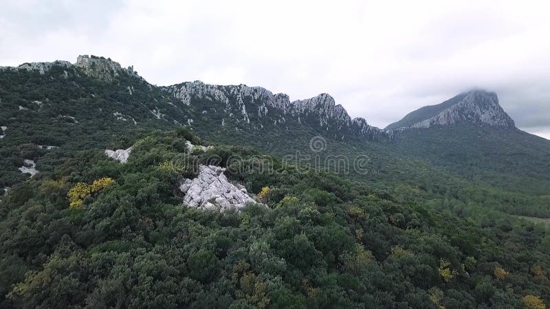 Aerial Drone Footage View: Flight over cloudy mountains with forests. Pic Saint Loup, Hortu