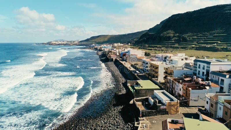 aerial drone i beautiful stunning surf beach with waves and swell coming in in front of a traditional tiny cute village high cliff stock photos aerial drone i beautiful stunning surf beach with waves and swell coming in in front of a traditional tiny cute village high cliff stock photos