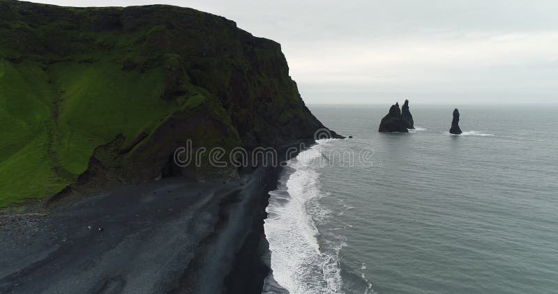 Aerial drone video of Iceland famous black sand beach Reynisfjara with people