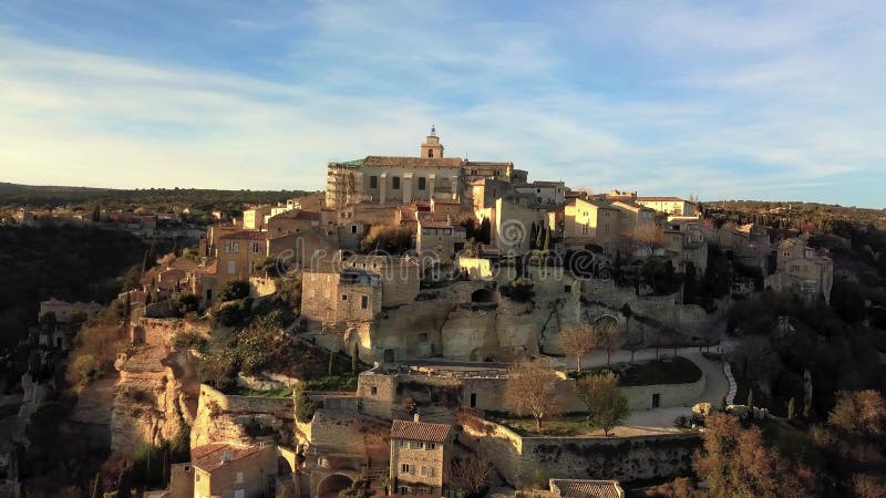 Aerial drone view of Gordes, labelled Most Beautiful Villages of France, perched on a rocky outcrop at the end of the Vaucluse pla