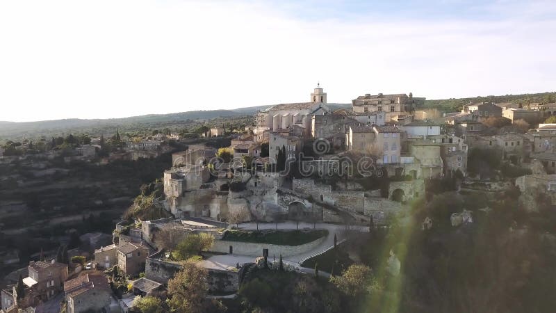 Aerial drone view of Gordes, labelled Most Beautiful Villages of France, perched on a rocky outcrop at the end of the Vaucluse pla