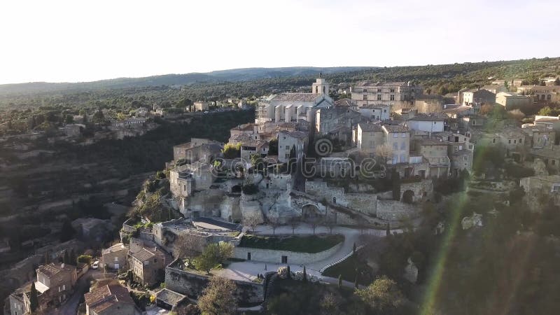 Aerial drone view of Gordes, labelled Most Beautiful Villages of France, perched on a rocky outcrop at the end of the Vaucluse pla