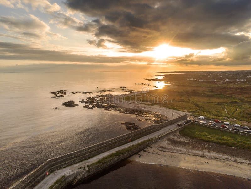 Aerial drone view on a Spiddal stone pier. County Galway, Ireland. Atlantic ocean, Sunset time. Dramatic sky