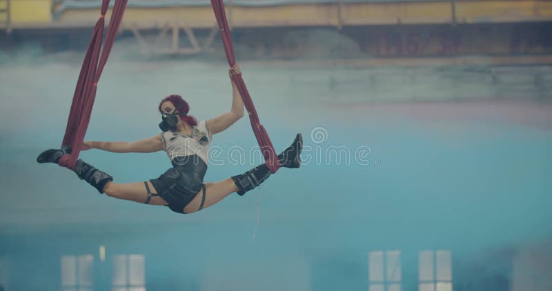 Aerial Gymnastics, Woman Doing a Split in the Air between Two Red