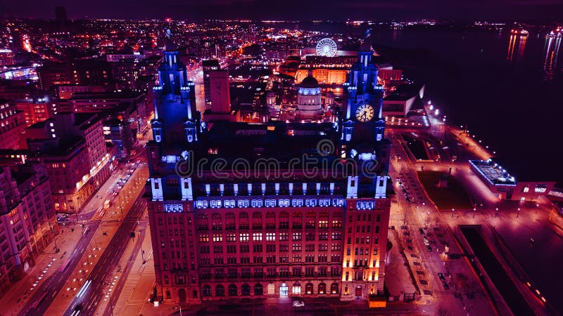 Vedere aeriană de noapte a unei clădiri istorice iluminate într-un mediu urban cu lumini de fundal în Liverpool Uk stock photos