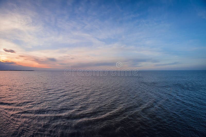 Aerial panoramic view of sunset over ocean. Nothing but sky, clouds and water