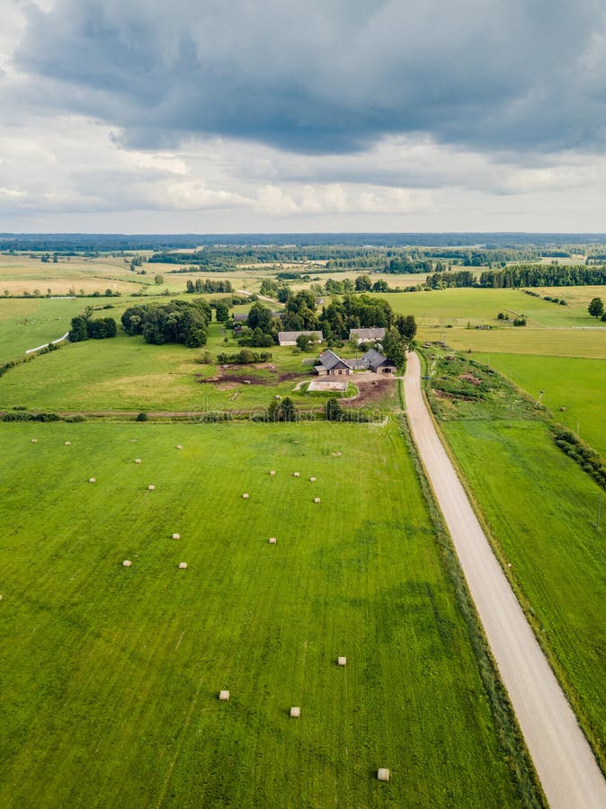 Aerial Photo of old Farmer houses with Road by its Side and Agriculture Fields Around it in Early Spring on Sunny Day