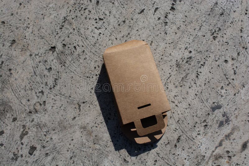 Aerial Shot Of A Thick Brown Paper Bag Lying On A Concrete Floor