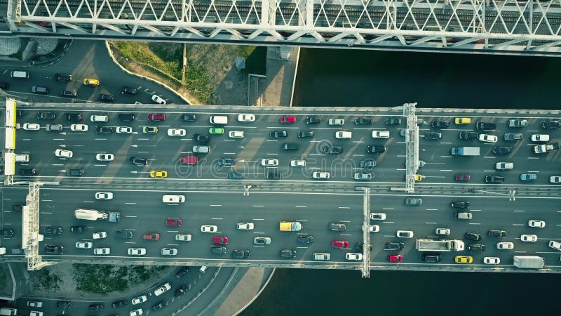 Aerial top down view of traffic jam on a car bridge and moving train