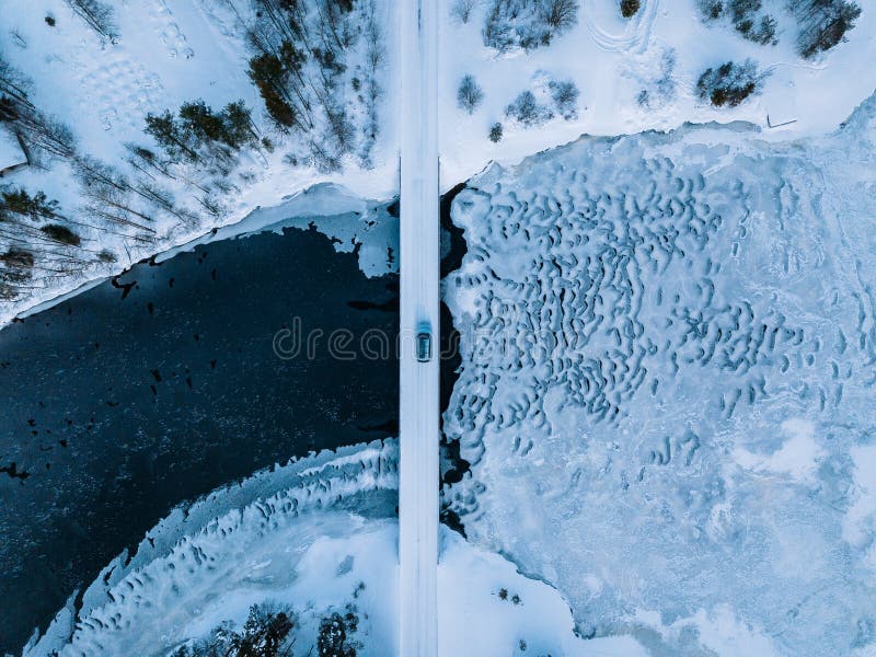 Aerial top view of bridge road above frozen river in snow winter Finland stock photo Aerial top view of bridge road above frozen river in snow winter Finland stock photo