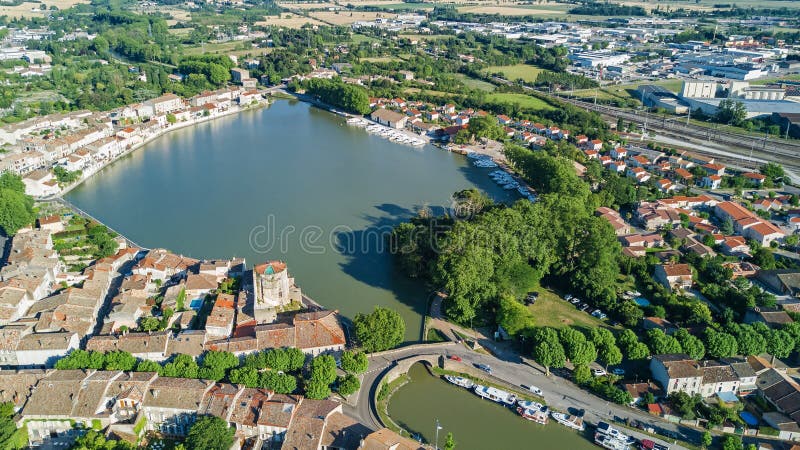 Aerial top view of Castelnaudary residential area houses roofs, streets and canal with boats from above, old medieval town background, France