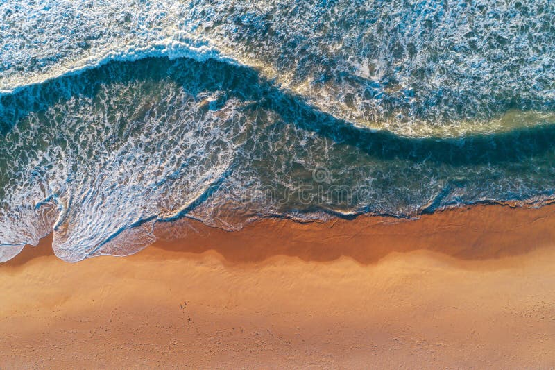Aerial top view from drone of sandy beach with turquoise sea waves with copy space for text stock image