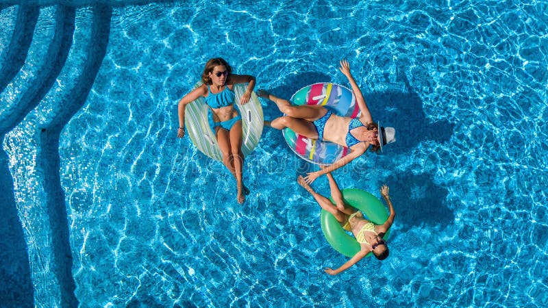 Aerial top view of family in swimming pool from above, happy mother and kids swim on inflatable ring donuts and have fun in water. On family vacation, tropical royalty free stock photography Aerial top view of family in swimming pool from above, happy mother and kids swim on inflatable ring donuts and have fun in water. On family vacation, tropical royalty free stock photography